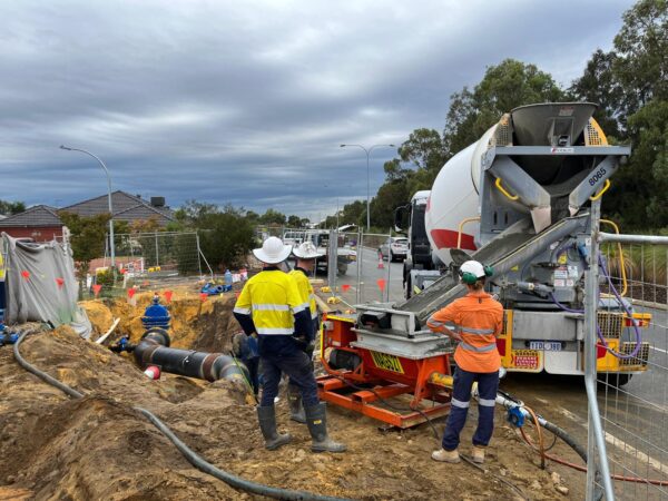 The team from Grout Pump Hire Perth monitoring the cement from the truck being added to the grout pump